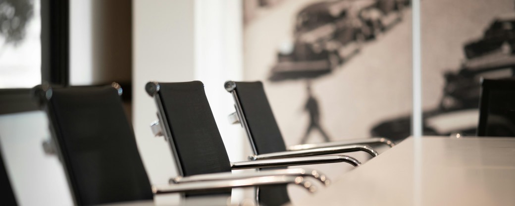 Office chairs in a row along a meeting table.