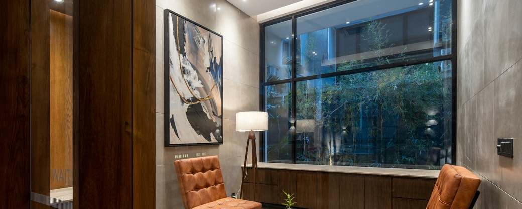 Two leather armchairs and a small table beside a window.